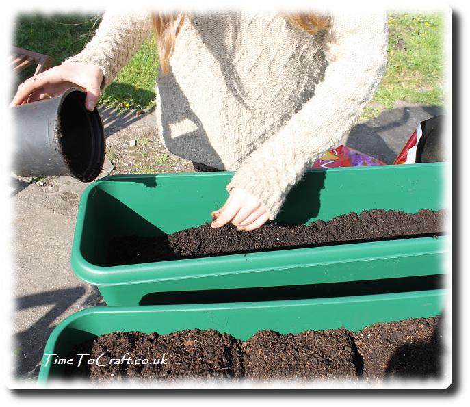 Adding soil to the children's planters