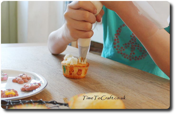 piping fondant onto cupcake childs baking activity