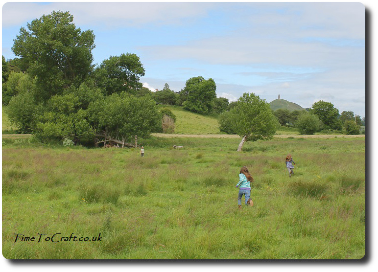 running in meadow Glastonbury Tor
