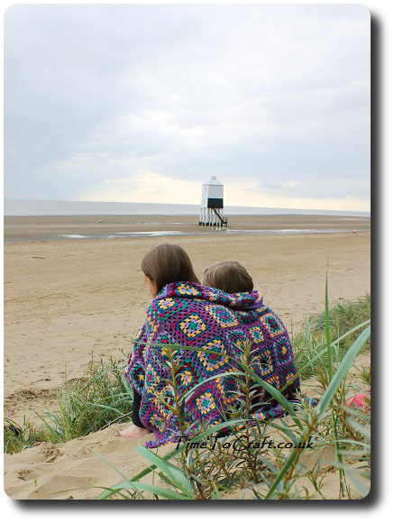 sisters on the beach with crochet blanket