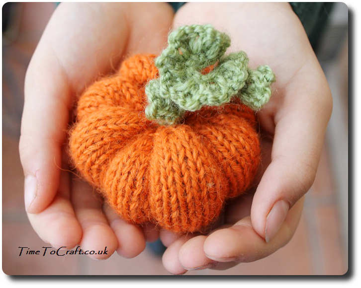 knitted pumpkin in hands